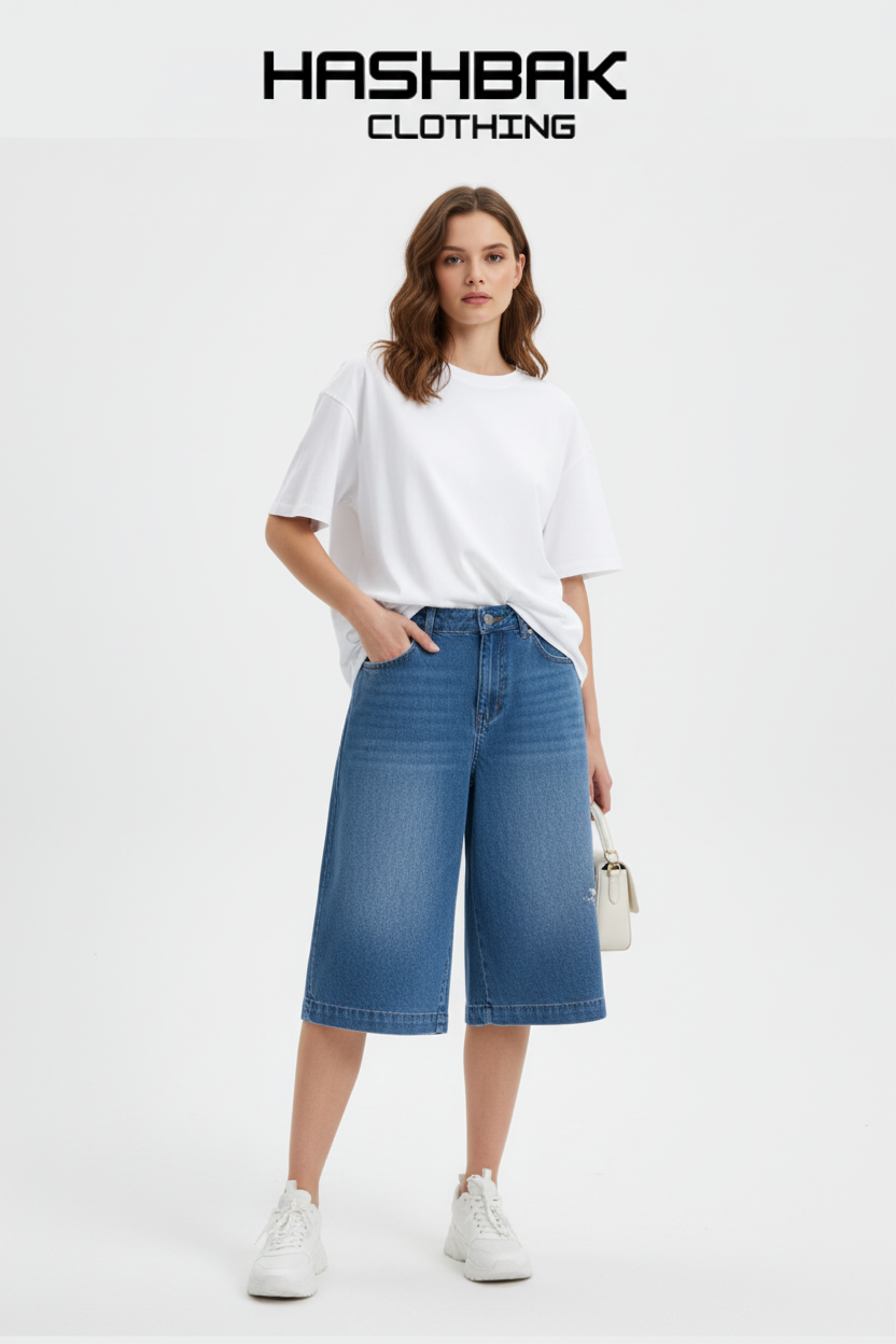 Model wearing medium-blue wide-leg denim shorts - Studio shot